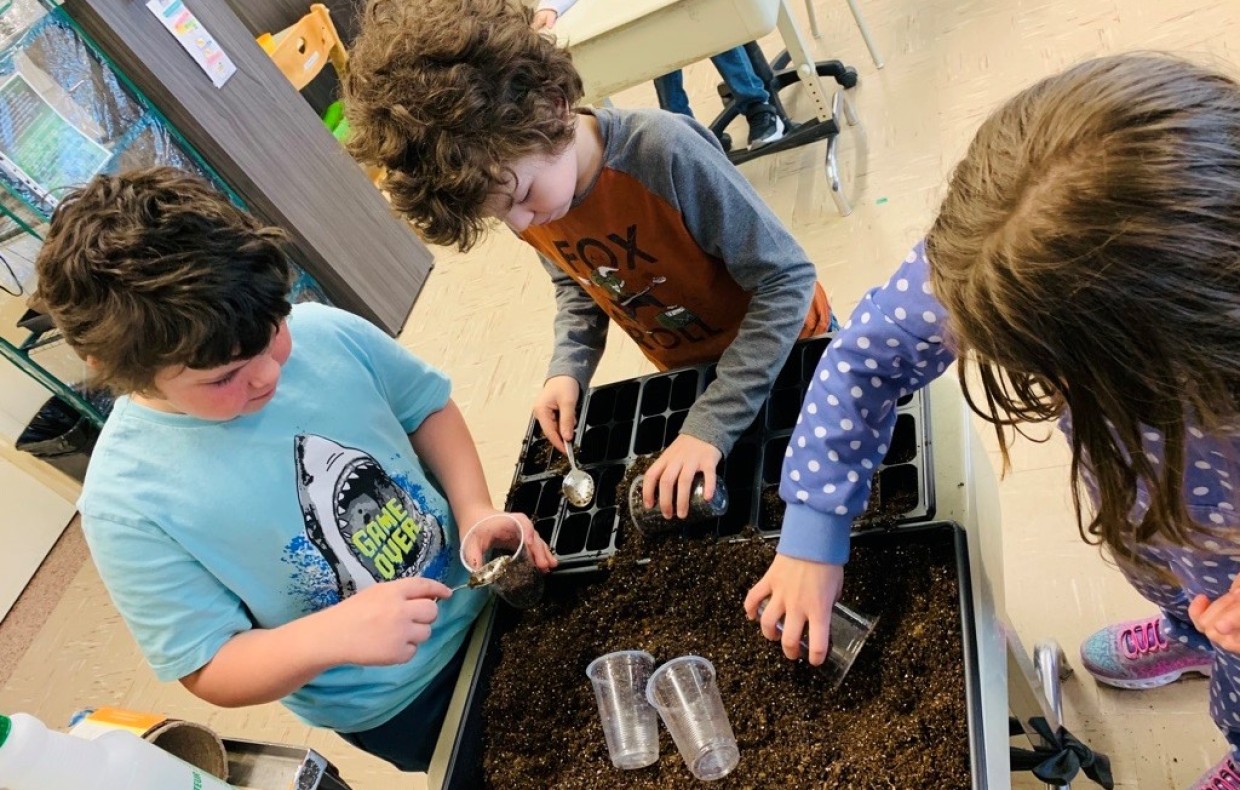 Élèves de l'école La Myriade qui travail dans le jardin pédagogique